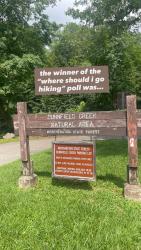 photo of sign to entrance of "dunnfield creek natural area" captioned "the winner of the where should i go hiking poll was"